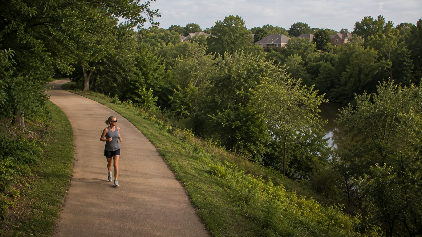 Woman jogging on Wolf River greenway trail in Germantown Tennessee on a weekday morning