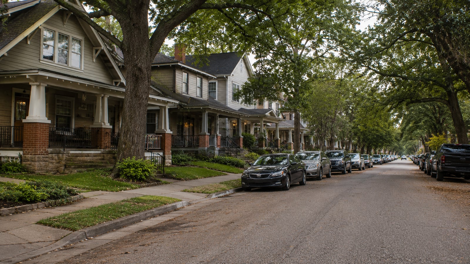 Cooper-Young neighborhood street in Memphis showing converted rental bungalows with mature trees and dense on-street parking